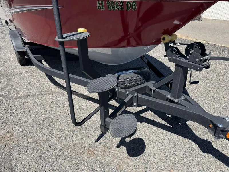 Slide: The Image of 2024 Tracker Targa™ V-18 Combo boat trailer with red hull and step ladder. - 13