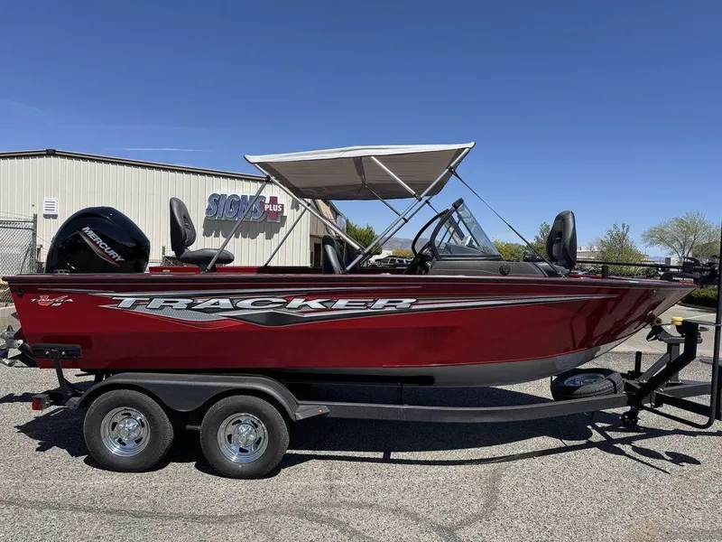 Slide: The Image of 2024 Tracker Targa™ V-18 Combo boat, red, on trailer, parked outdoors. - 3