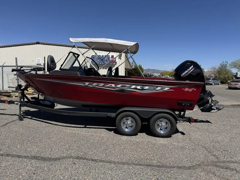 Slide: The Image of 2024 Tracker Targa™ V-18 Combo boat on trailer, red exterior, parked outdoors. - 43