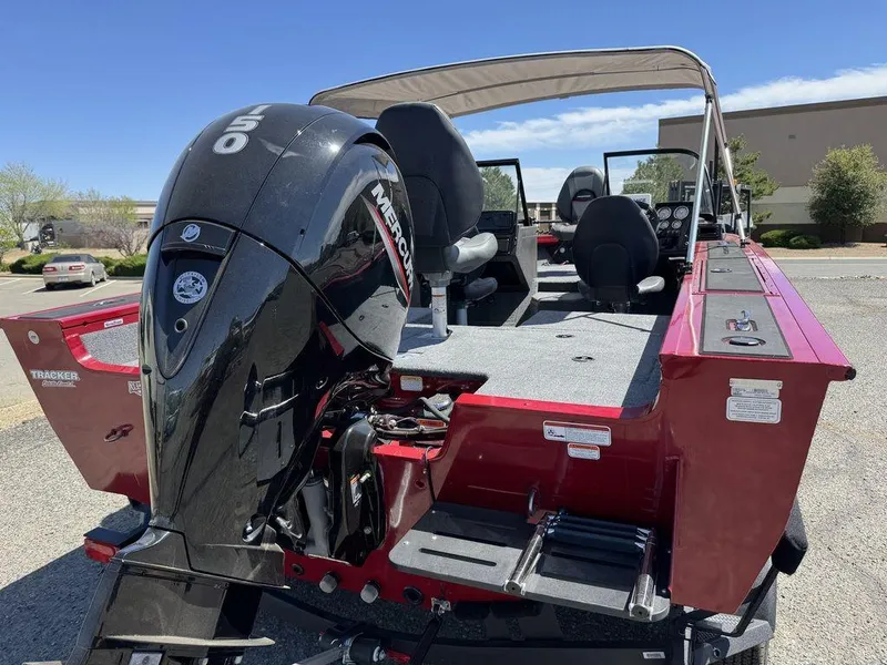 Slide: The Image of 2024 Tracker Targa™ V-18 Combo boat with Mercury engine, red exterior, parked outdoors. - 6