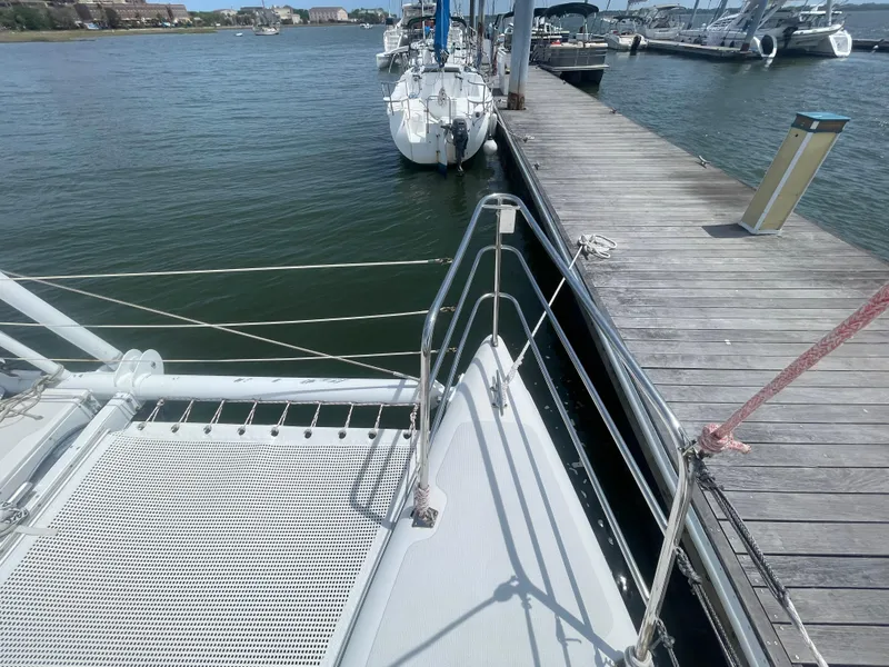 Slide: The Image of Seawind 1000 catamaran docked at marina, 2001 model, with clear water and wooden pier. - 10