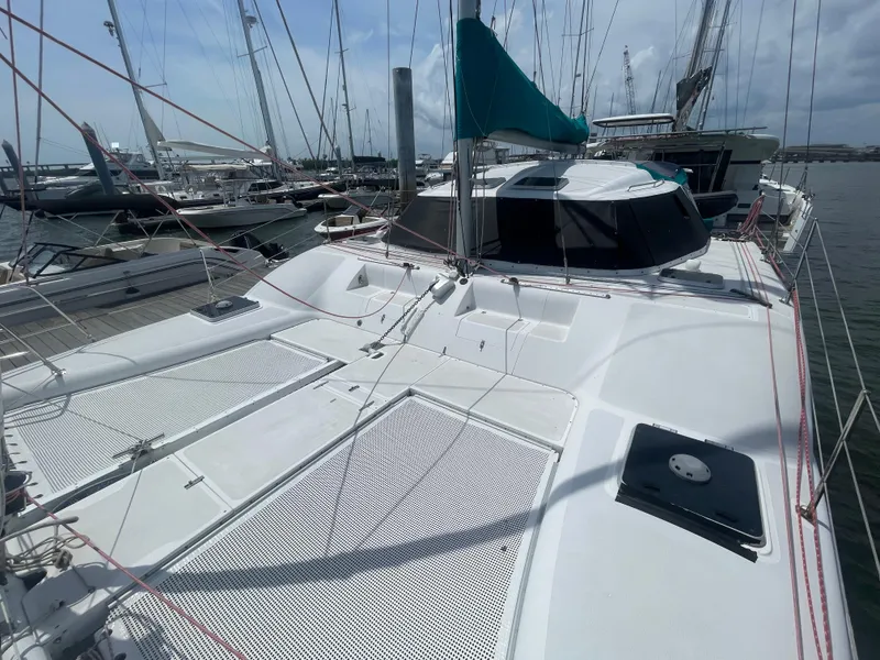 Slide: The Image of 2001 Seawind 1000 catamaran docked at marina, featuring spacious deck and modern design. - 17