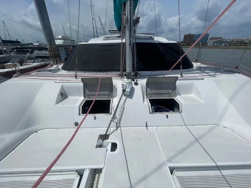 Slide: The Image of 2001 Seawind 1000 catamaran deck with open hatches, docked in a marina. - 18