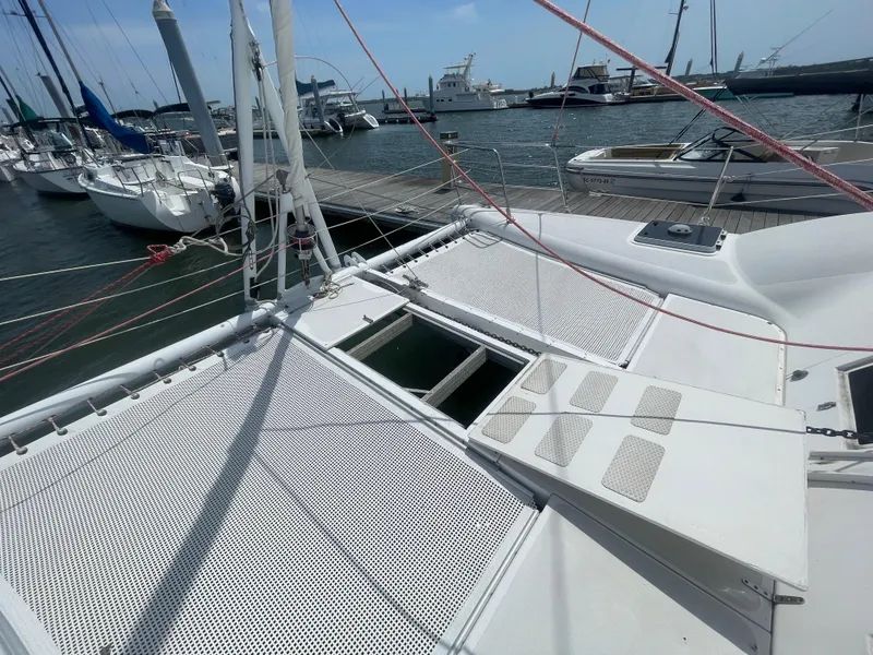 Slide: The Image of Seawind 1000 catamaran, 2001 model, docked at marina with visible netting and deck. - 19