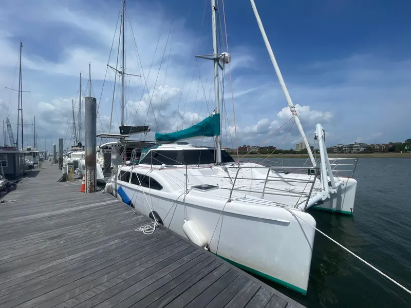 Slide: The Image of 2001 Seawind 1000 catamaran docked at a marina under a clear blue sky. - 2