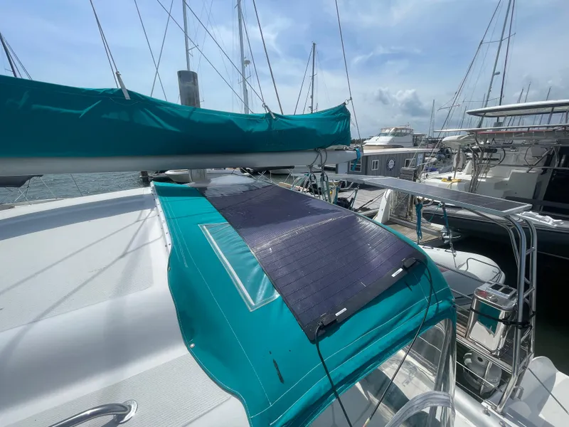 Slide: The Image of Seawind 1000 catamaran, 2001 model, docked with teal canopy and solar panel. - 26