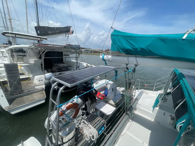 Slide: The Image of Seawind 1000 catamaran, 2001 model, docked with solar panels and turquoise canopy. - 28