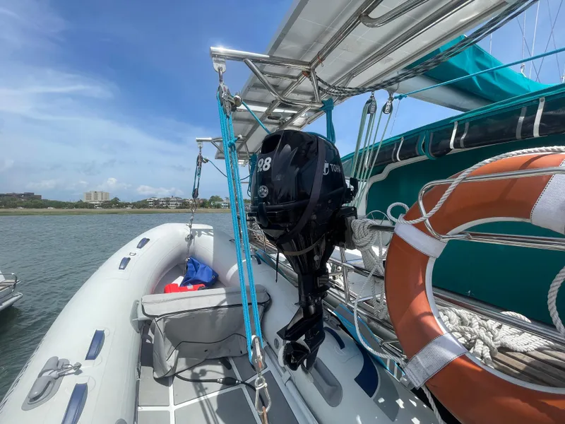 Slide: The Image of Seawind 1000 catamaran with outboard motor and lifebuoy, docked by the shore, 2001 model. - 29