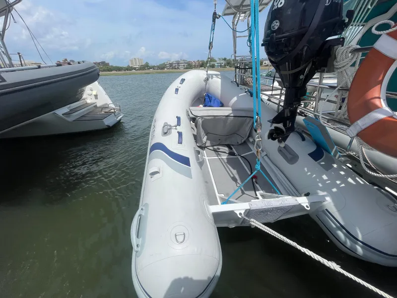 Slide: The Image of 2001 Seawind 1000 catamaran with inflatable dinghy and outboard motor docked on calm water. - 30