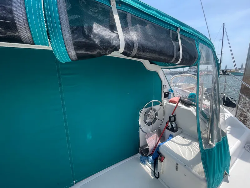 Slide: The Image of Seawind 1000 catamaran cockpit with teal canopy, steering wheel, and clear side panels, 2001 model. - 35