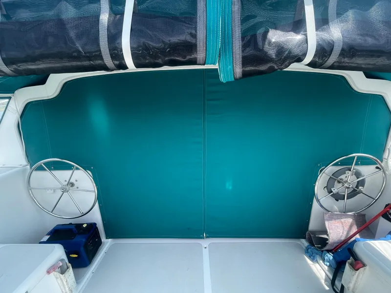 Slide: The Image of Seawind 1000 catamaran cockpit with dual steering wheels, turquoise cover, and storage compartments. - 37