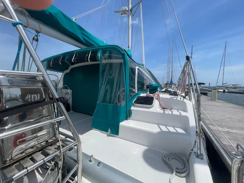 Slide: The Image of Seawind 1000 catamaran, 2001 model, docked at marina with teal canopy and clear skies. - 6