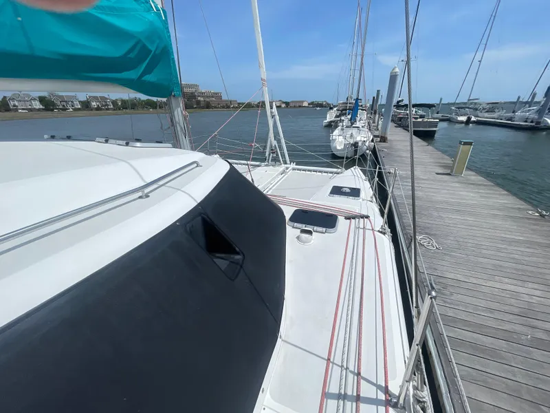 Slide: The Image of Seawind 1000 catamaran docked at marina, showcasing deck and sails, 2001 model. - 8