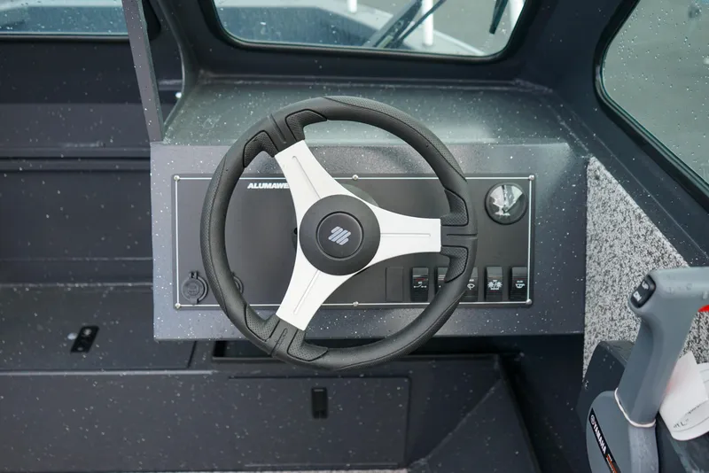 Slide: The Image of Steering wheel of 2025 Alumaweld Stryker X202 boat, showcasing dashboard controls. - 12