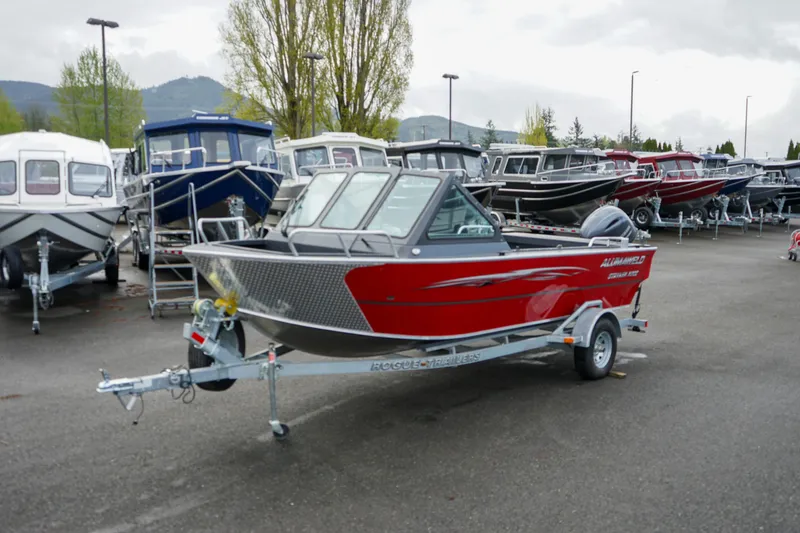 Slide: The Image of 2025 Alumaweld Stryker X202 boat in a dealership lot, vibrant red color, on a trailer. - 2