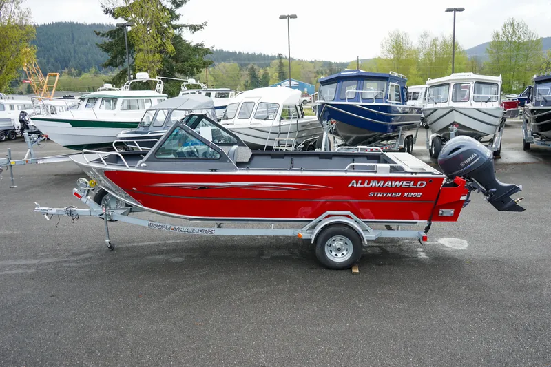 Slide: The Image of 2025 Alumaweld Stryker X202 boat, red, on trailer in a marina parking lot. - 4