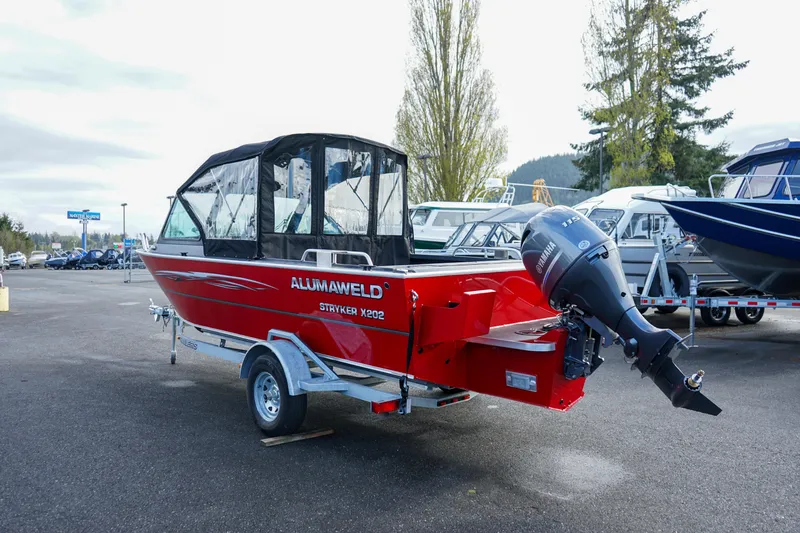 Slide: The Image of 2025 Alumaweld Stryker X202 boat, red exterior, on trailer, parked outdoors. - 5
