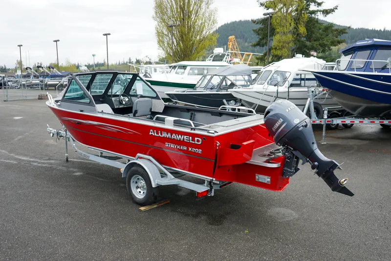 Slide: The Image of 2025 Alumaweld Stryker X202 boat, red, on trailer in marina parking lot. - 6