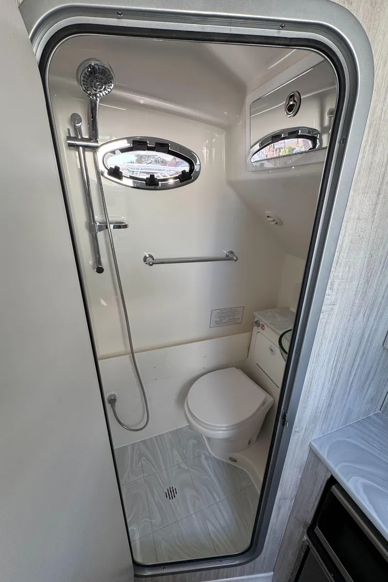 Slide: The Image of 2025 Regulator 37 boat bathroom with shower, toilet, and porthole windows. - 15