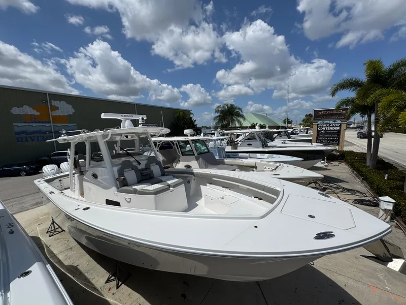 Slide: The Image of 2025 Regulator 37 boat displayed outdoors under a partly cloudy sky. - 2