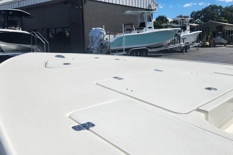 Slide: The Image of 2026 ShearWater X22 HYBRID boat on display at a dealership with other boats. - 14