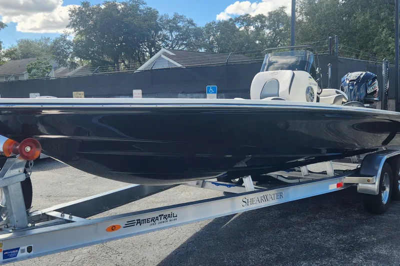Slide: The Image of 2026 ShearWater X22 HYBRID boat on trailer, parked outdoors under a clear sky. - 15
