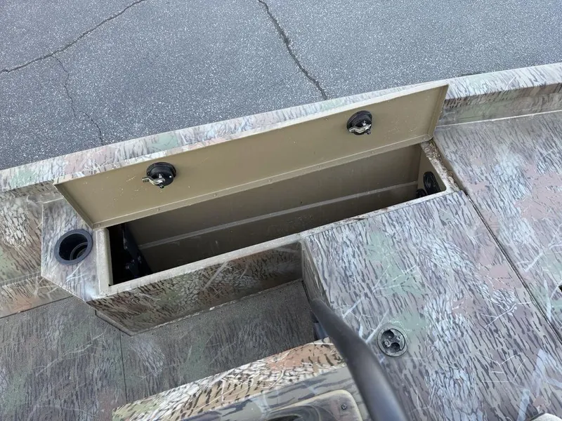 Slide: The Image of 2019 G3 Gator Tough 20 CCJ boat storage compartment with camo design, open lid, and cup holders. - 11