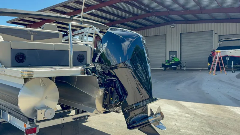 Slide: The Image of 2023 Barletta CABRIO 24 UC pontoon boat with powerful outboard motor in a storage facility. - 14