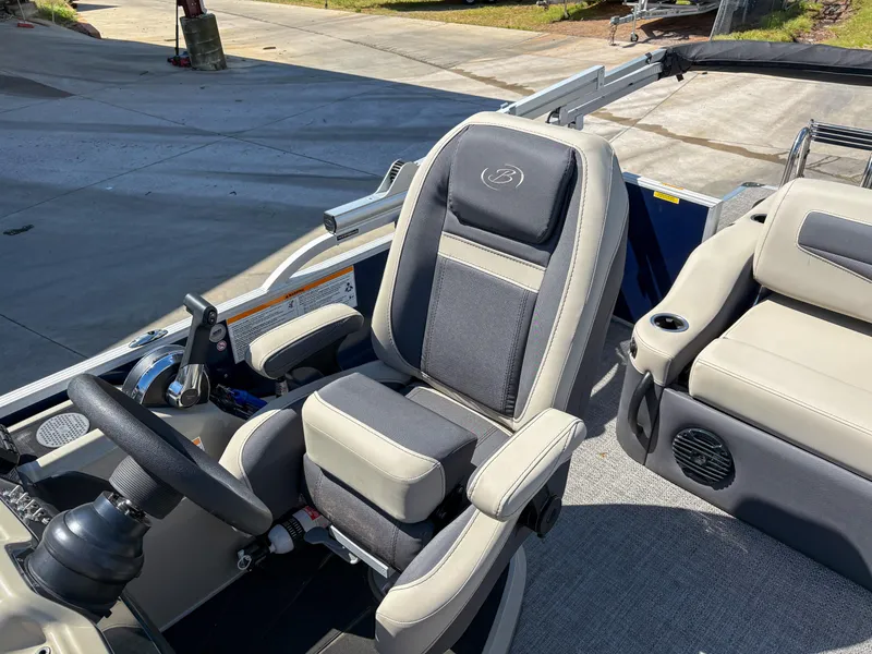 Slide: The Image of 2023 Barletta CABRIO 24 UC boat interior with plush seating and steering wheel. - 7