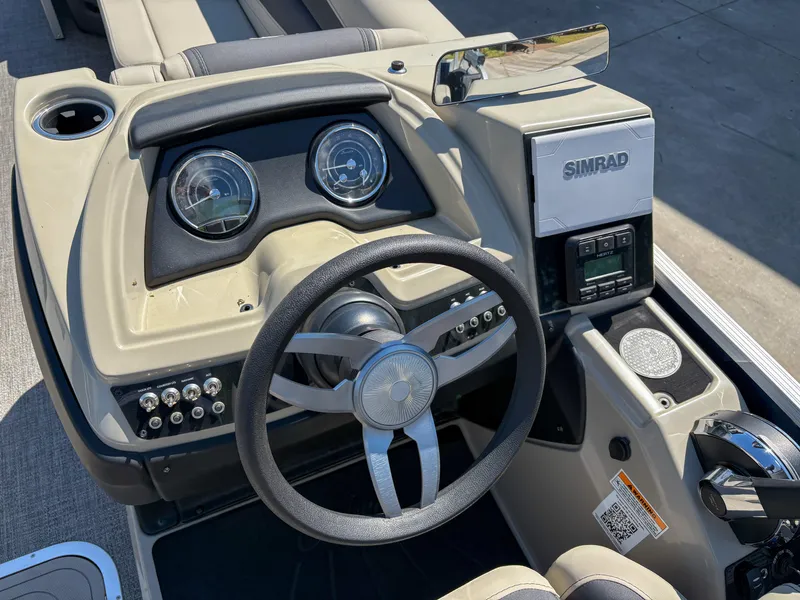 Slide: The Image of 2023 Barletta Cabrio 24 UC boat dashboard with steering wheel and Simrad display. - 9