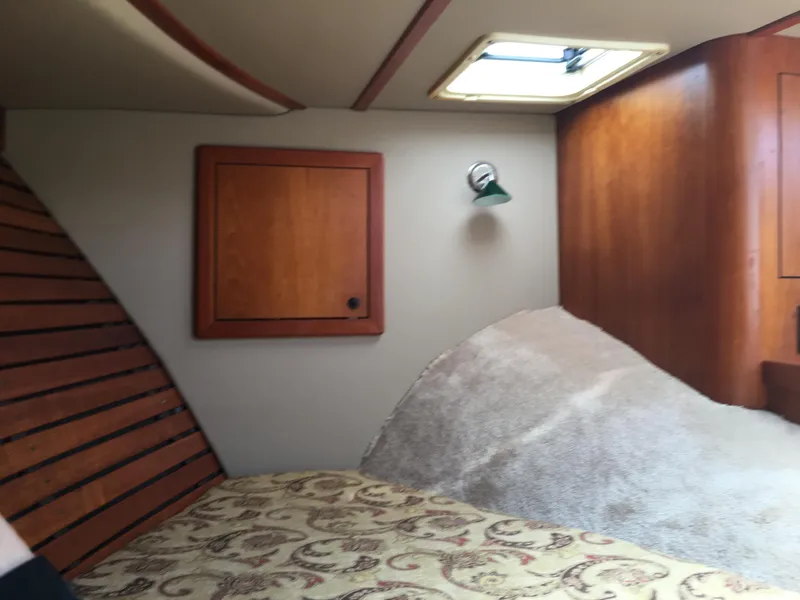 Slide: The Image of Cozy cabin interior of 2008 Calcutta 390 boat with wooden accents and patterned bedding. - 19