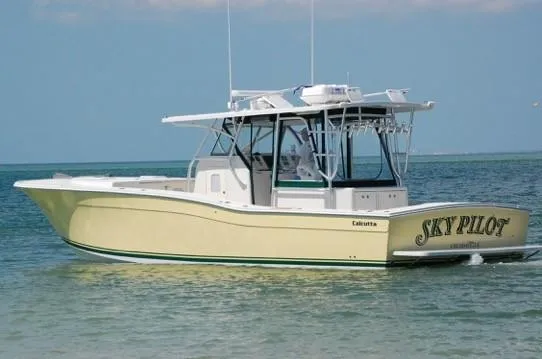 Slide: The Image of 2008 Calcutta 390 boat named "Sky Pilot" on calm water. - 2