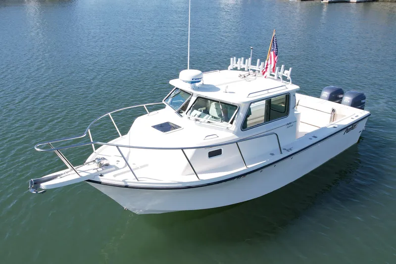 Slide: The Image of 2008 Parker 2520 DV boat on calm water, featuring a sleek white design and American flag. - 1