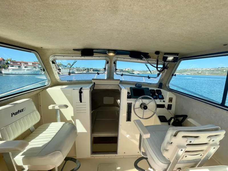 Slide: The Image of Interior of a 2008 Parker 2520 DV boat with steering wheel and seating. - 10