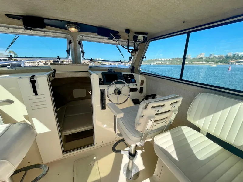 Slide: The Image of Interior of 2008 Parker 2520 DV boat with steering wheel and seating. - 11