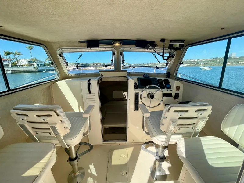 Slide: The Image of 2008 Parker 2520 DV boat interior with helm, seats, and water view. - 12