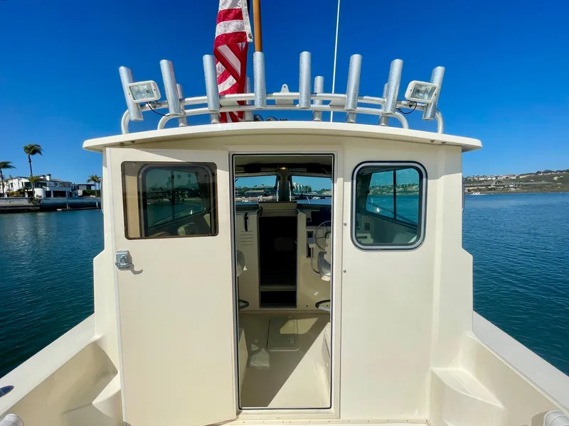 Slide: The Image of 2008 Parker 2520 DV boat with open cabin doors, docked in a sunny marina. - 15