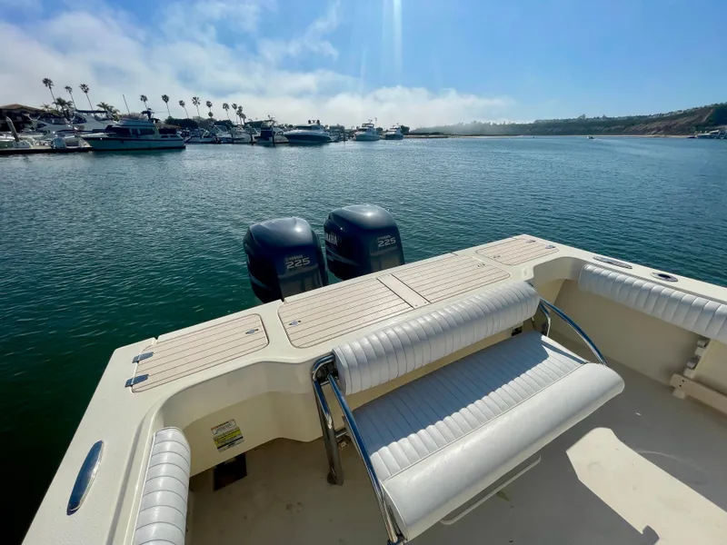 Slide: The Image of 2008 Parker 2520 DV boat with dual engines, docked in a marina under clear skies. - 17