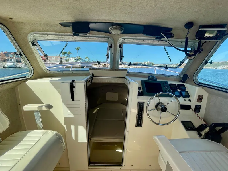 Slide: The Image of Interior of 2008 Parker 2520 DV boat cockpit with steering wheel and navigation controls. - 9