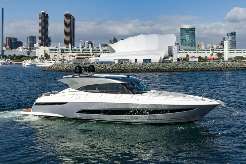 Slide: The Image of 2023 Riviera 5400 Sport Yacht cruising in urban waterfront setting. - 11