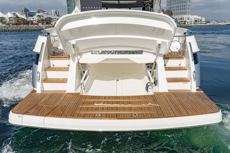 Slide: The Image of 2023 Riviera 5400 Sport Yacht with open swim platform on water. - 16