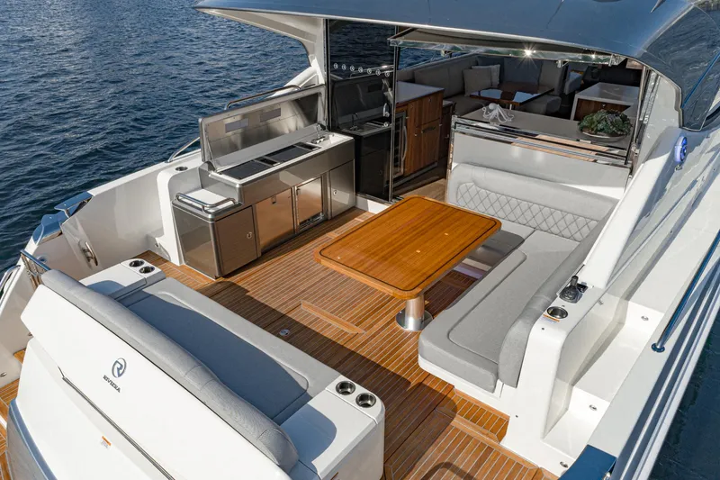 Slide: The Image of 2023 Riviera 5400 Sport Yacht with outdoor seating and kitchenette on deck. - 21