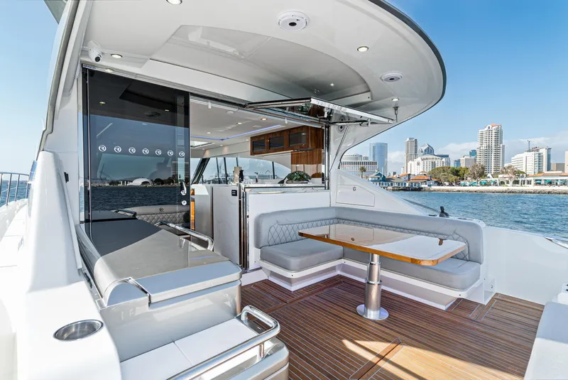Slide: The Image of 2023 Riviera 5400 Sport Yacht with luxurious deck seating and city skyline view. - 24