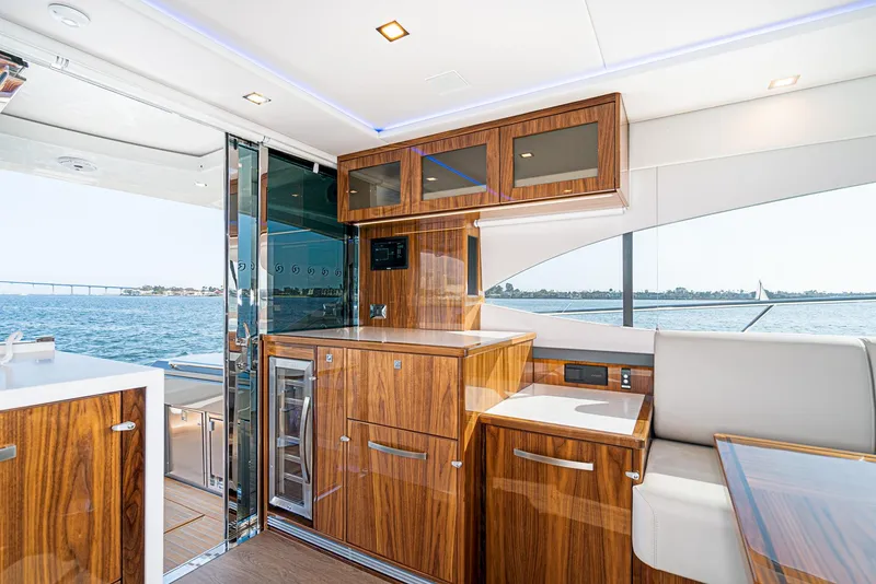 Slide: The Image of 2023 Riviera 5400 Sport Yacht interior with elegant wood cabinetry and ocean view. - 30