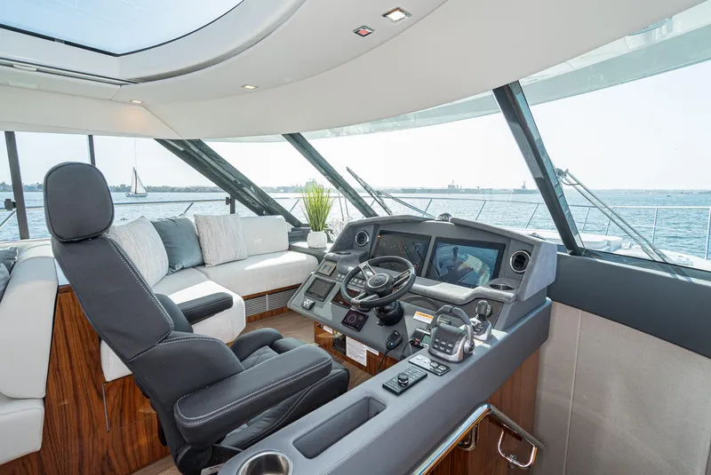Slide: The Image of 2023 Riviera 5400 Sport Yacht interior with modern helm and panoramic ocean view. - 37