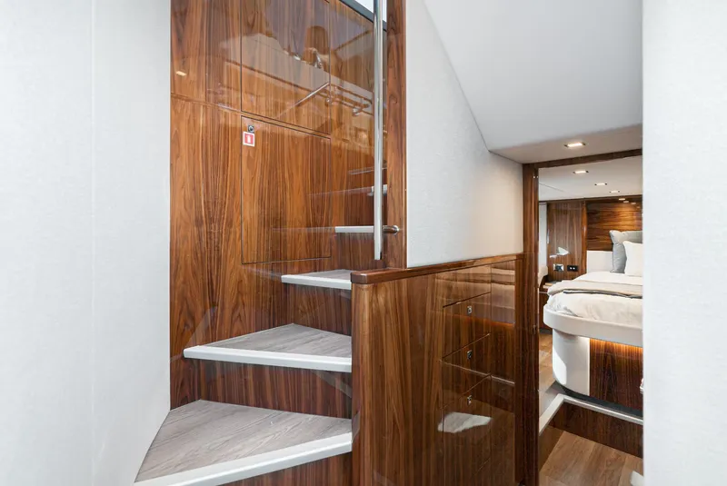 Slide: The Image of Interior of 2023 Riviera 5400 Sport Yacht with wooden stairs and modern bedroom. - 38