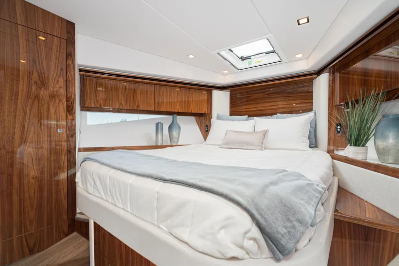 Slide: The Image of Luxurious bedroom interior of 2023 Riviera 5400 Sport Yacht with elegant wood finishes. - 45