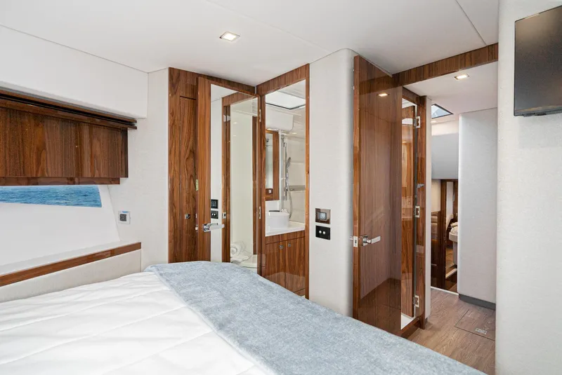 Slide: The Image of Luxurious interior of 2023 Riviera 5400 Sport Yacht bedroom with wood accents. - 46