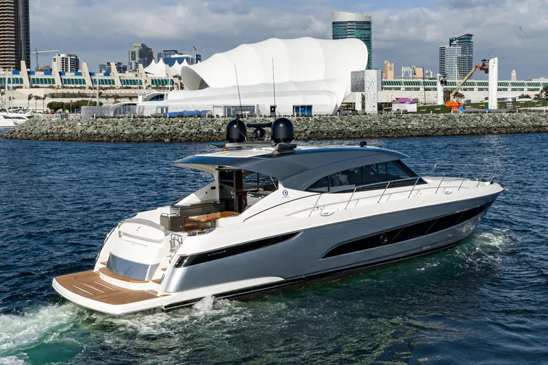 Slide: The Image of 2023 Riviera 5400 Sport Yacht cruising near urban waterfront. - 9