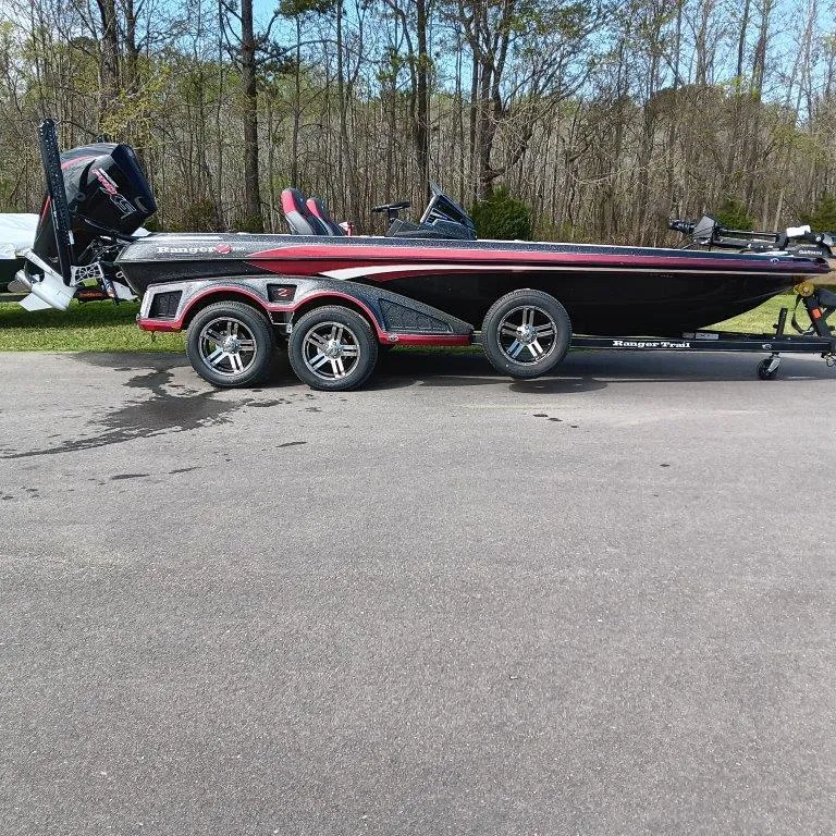 Slide: The Image of 2025 Ranger Z520 boat on trailer, parked on road with forest background. - 0